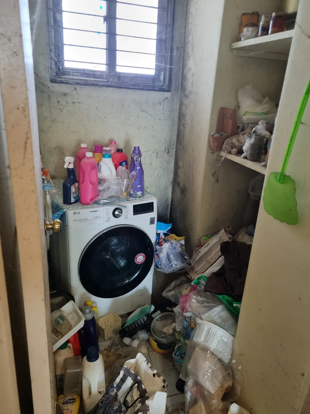 세탁기 주변에 잡동사니가 쌓인 다용도실